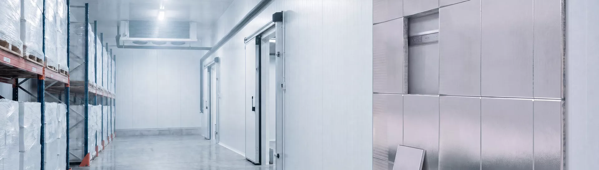 Cold chain - Salle de stockage frigorifiée avec murs blancs et étagères.