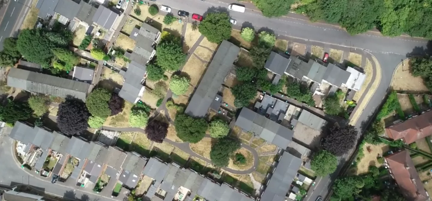 Aerial view of a residential area with houses and greenery.