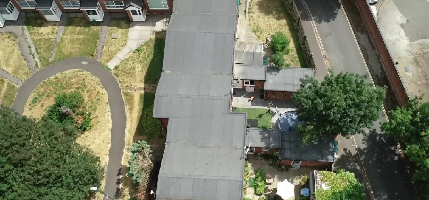 Aerial view of a residential area with a winding path and trees.
